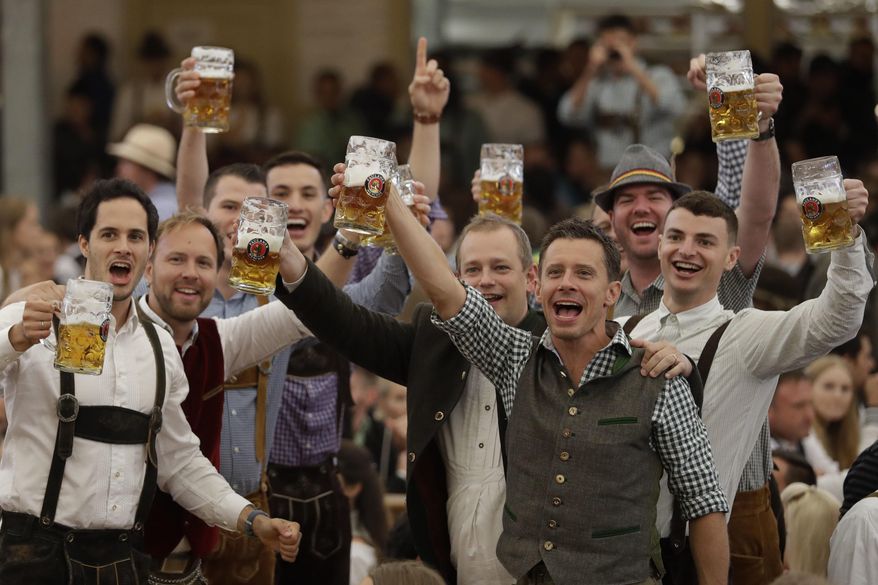 Young men celebrate the opening of the 184th Oktoberfest beer festival in the "Paulaner brewery" tent in Munich, Germany, Saturday, Sept. 16, 2017. The world's largest beer festival was held from Sept. 16 until Oct. 3. (AP Photo/Matthias Schrader) ** FILE **