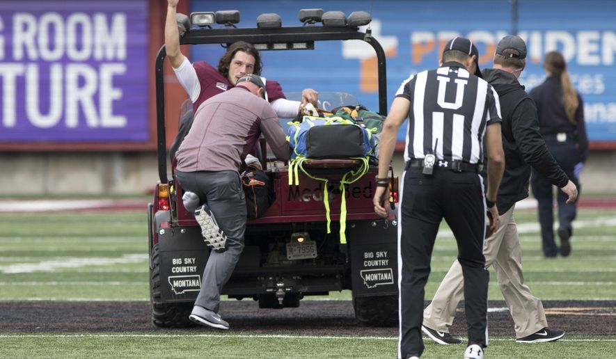 Montana quarterback Reese Phillips (11) acknowledges the crowd as he is being taken off the field on a cart after an injury against Savannah State in an NCAA college football game Saturday, Sept. 16, 2017, in Missoula, Mont. (AP Photo/Patrick Record)