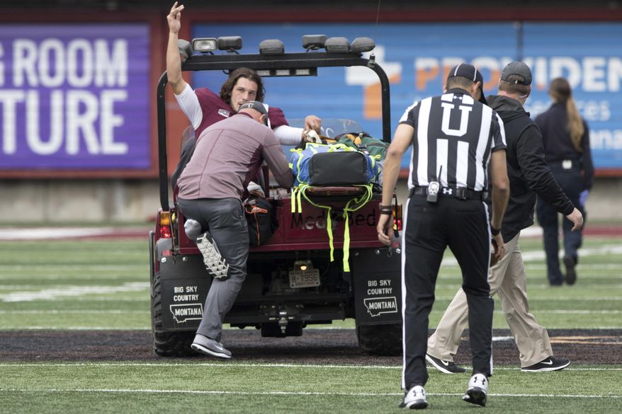 Montana quarterback Reese Phillips (11) acknowledges the crowd as he is being taken off the field on a cart after an injury against Savannah State in an NCAA college football game Saturday, Sept. 16, 2017, in Missoula, Mont. (AP Photo/Patrick Record)