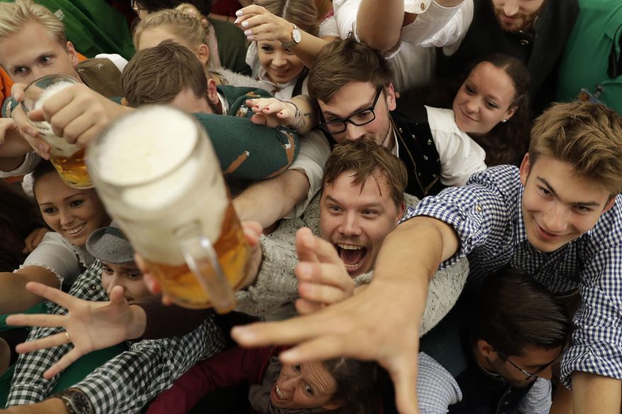 Young people struggle for beer during the opening of the 184th Oktoberfest beer festival in Munich, Germany, Saturday, Sept. 16, 2017. (AP Photo/Matthias Schrader) ** FILE **
