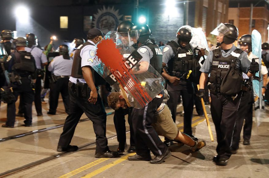 Police arrest a man as they try to clear a violent crowd Saturday, Sept. 16, 2017, in University City, Mo. Earlier, protesters marched peacefully in response to a not guilty verdict in the trial of former St. Louis police officer Jason Stockley. (AP Photo/Jeff Roberson)