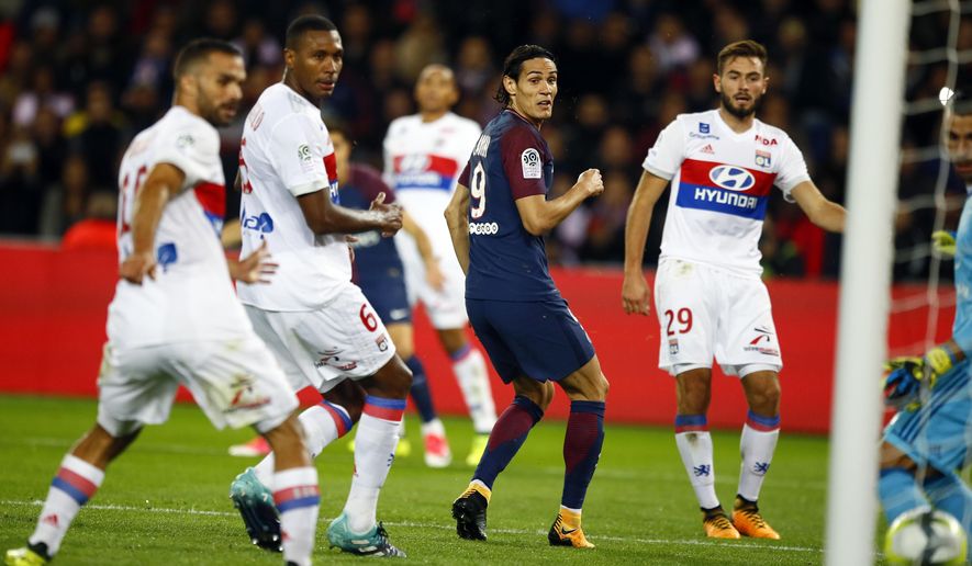 Paris Saint Germain&#39;s Edison Cavani, center, eyes the ball after scoring the first goal against Lyon during their French League One soccer match between PSG and Olympique Lyon at the Parc des Princes stadium in Paris, France, Sunday, Sept. 17, 2016. (AP Photo/Francois Mori)
