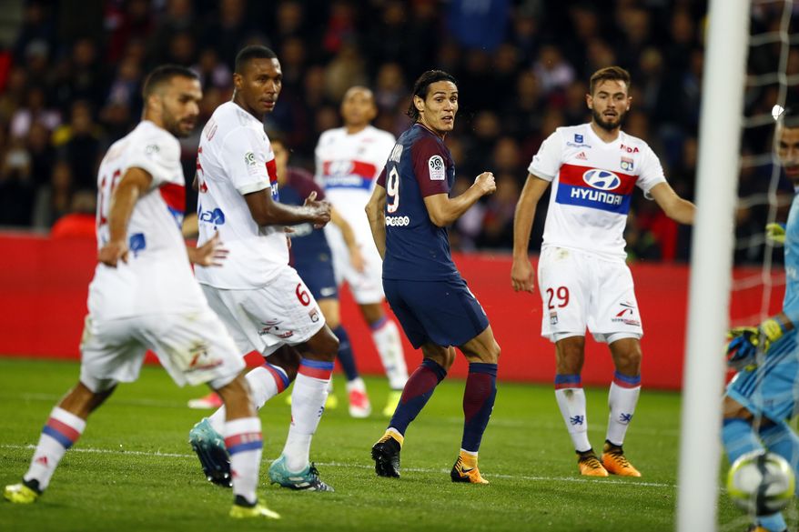 Paris Saint Germain&#x27;s Edison Cavani, center, eyes the ball after scoring the first goal against Lyon during their French League One soccer match between PSG and Olympique Lyon at the Parc des Princes stadium in Paris, France, Sunday, Sept. 17, 2016. (AP Photo/Francois Mori)