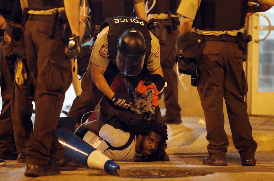 Police arrest a man as demonstrators march in response to a not guilty verdict in the trial of former St. Louis police officer Jason Stockley, Sunday, Sept. 17, 2017, in St. Louis. Stockley was acquitted in the 2011 killing of a black man following a high-speed chase. (AP Photo/Jeff Roberson)