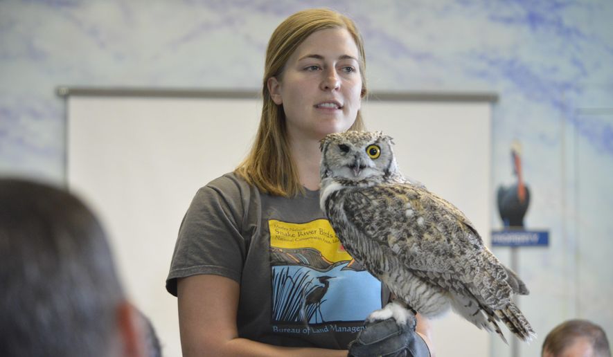 Corrine Coffman, with the Bureau of Land Management operated Morley Nelson Snake River Birds of Prey National Conservation Area, holds Great Horned Owl, Archimedes, as inmates from Snake River Correctional Institution look on, Sept. 8, 2017. The lecture took place at Snake River Correctional Institution. (Hunter Marrow /Argus Observer via AP)
