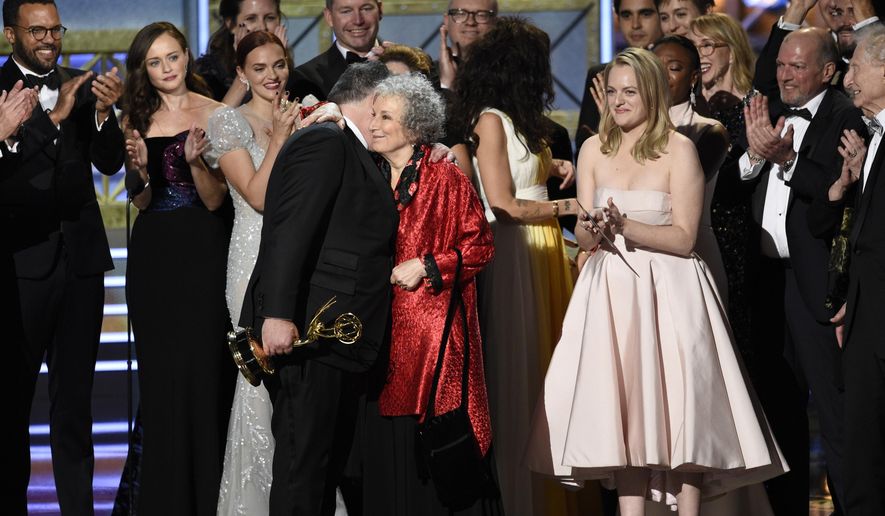 Bruce Miller, from left, Margaret Atwood, and Elisabeth Moss accept the award for outstanding drama series for &quot;The Handmaid&#39;s Tale&quot; at the 69th Primetime Emmy Awards on Sunday, Sept. 17, 2017, at the Microsoft Theater in Los Angeles. (Photo by Chris Pizzello/Invision/AP) ** FILE **