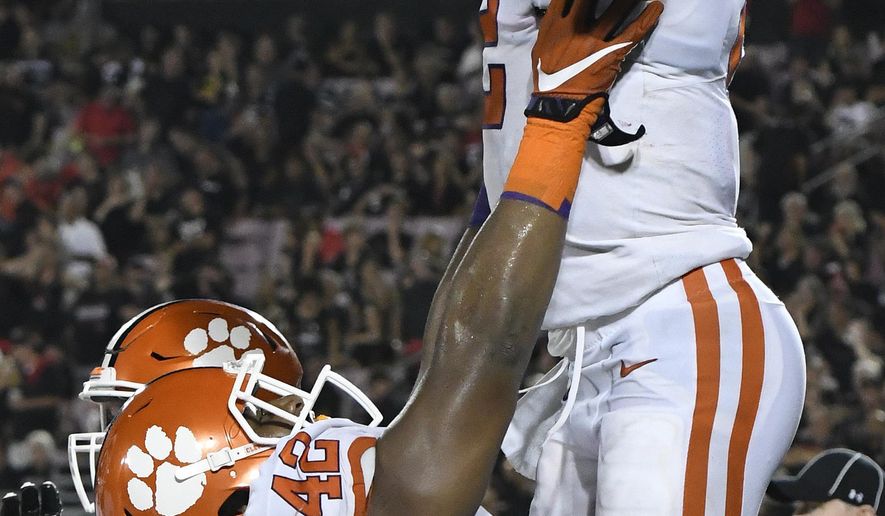 Clemson's linebacker Jarvis Magwood (46) holds up Kelly Bryant (2) following his touchdown during the second half of their NCAA college football game against Louisville, Saturday, Sept. 16, 2017, in Louisville, Ky. Clemson won 47-21. (AP Photo/Timothy D. Easley)