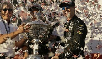 Josef Newgarden, right, stands and celebrates after being presented the Astor Cup for winning the IndyCar championship Sunday, Sept. 17, 2017, in Sonoma, Calif. Looking on at center is team owner Roger Penske. (AP Photo/Eric Risberg)