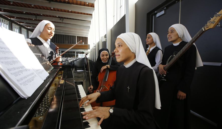 In this Thursday, Sept. 7, 2017, photo members of "Siervas," a Peruvian-based rock 'n' roll band comprised entirely of Catholic nuns rehearse a day ahead of their performance at performance at the Christ Cathedral campus in Garden Grove, Calif. The sisters insist they aren’t rock stars though they’re being considered for a nomination for a Latin Grammy and their concerts draw thousands. (AP Photo/Damian Dovarganes)