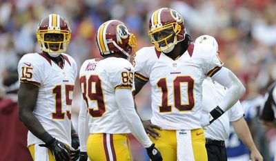 Washington Redskins quarterback Robert Griffin III (10) talks with teammates Santana Moss (89) and Josh Morgan (15) during a preseason NFL football game against the Indianapolis Colts, Saturday, Aug. 25, 2012, in Landover, Md. (AP Photo/Nick Wass)
