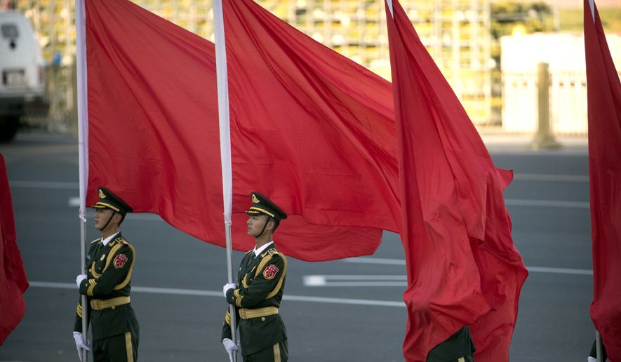 A Chinese honor guard member is caught in his flag as he stands at attention during a welcome ceremony for Singapore&#39;s Prime Minister Lee Hsien Loong at the Great Hall of the People in Beijing, Tuesday, Sept. 19, 2017. (AP Photo/Mark Schiefelbein)