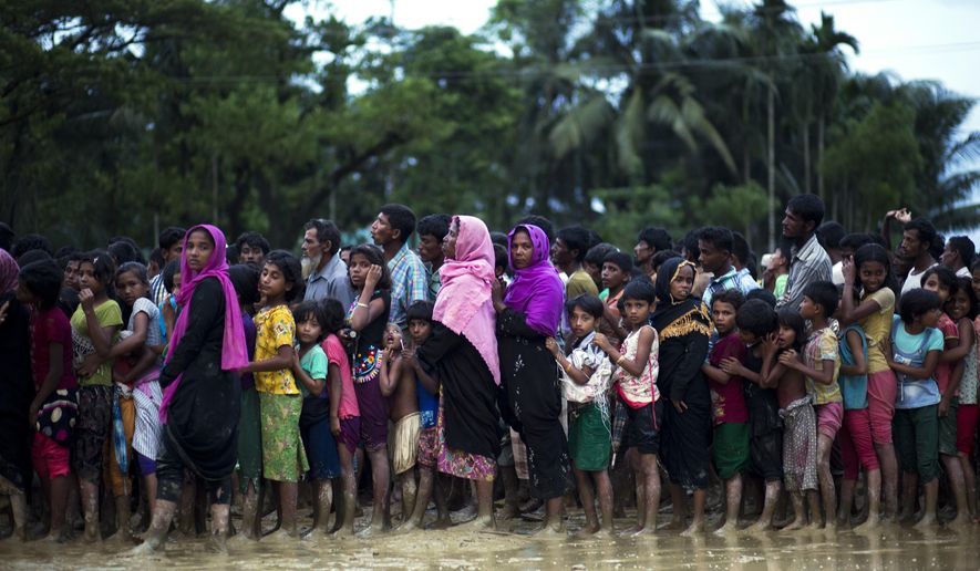 Rohingya Muslims, who crossed over recently from Myanmar into Bangladesh, stand in a queue to receive food being distributed near Balukhali refugee camp in Cox&#39;s Bazar, Bangladesh, Tuesday, Sept. 19, 2017. More than 500,000 Rohingya Muslims have fled to neighboring Bangladesh in the past year, most of them in the last three weeks, after security forces and allied mobs retaliated  to a series of attacks by Muslim militants last month by burning down thousands of Rohingya homes in the predominantly Buddhist nation. (AP Photo/Bernat Armangue)
