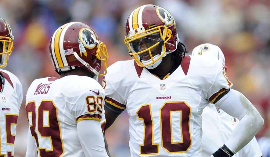 In this Aug. 25, 2012, file photo, Washington Redskins quarterback Robert Griffin III (10) talks with teammates Santana Moss (89)) during a preseason NFL football game against the Indianapolis Colts in Landover, Md. (AP Photo/Nick Wass, File)