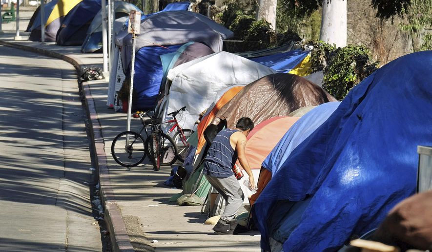 FILE - This Tuesday, Jan. 26, 2016 file photo shows a homeless encampment on a street in downtown Los Angeles. Public health authorities on Tuesday, Sept. 19, 2017, declared an outbreak of the highly contagious liver disease hepatitis A in Los Angeles County, the third California region to see significant infections this year. Health officials reported the outbreak to the county Board of Supervisors, which requested a briefing due to the proximity of LA to San Diego, which has had more than 420 cases and more than a dozen deaths since early this year. (AP Photo/Richard Vogel, File)