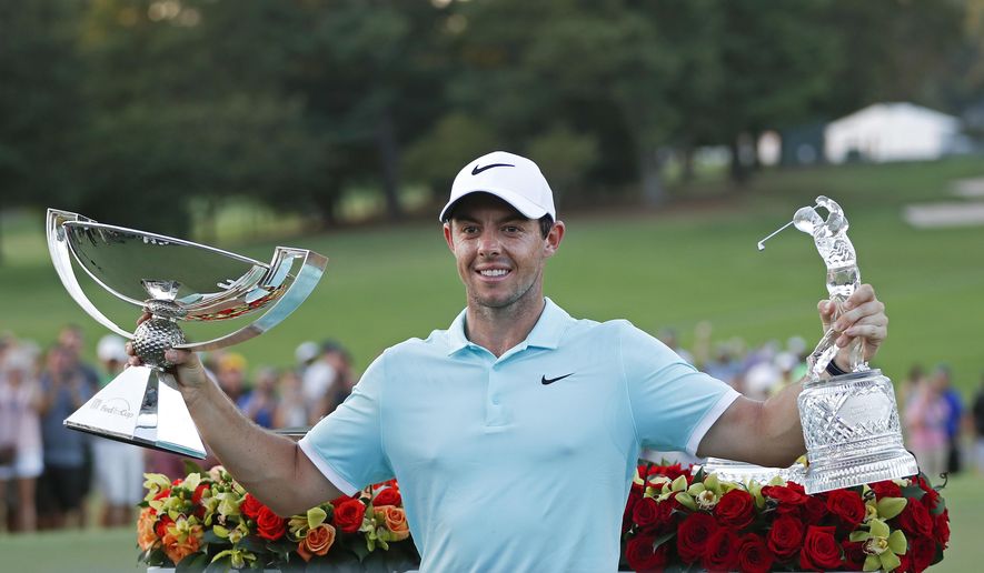 FILE - In this Sept. 25, 2016, file photo, Rory McIlroy poses with the trophies after winning the Tour Championship golf tournament and the FedEX Cup at East Lake Golf Club, in Atlanta. Along with revamping the PGA Tour schedule in two years, this would be a great time to change the format for the FedEx Cup. One plan under discussion with the players is to separate the Tour Championship from one final day worth $10 million to the winner.  (AP Photo/John Bazemore, File)
