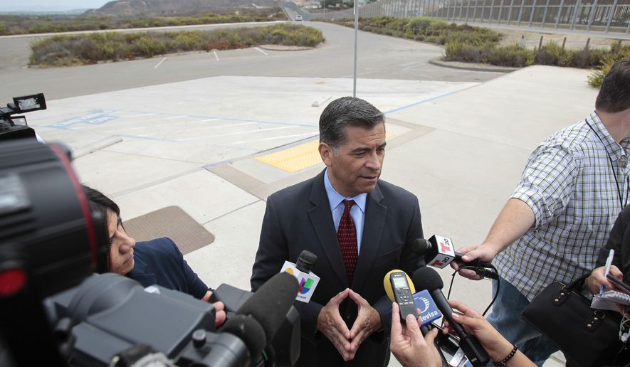 With the U.S Mexican border in the background, California State Attorney General Xavier Becerra talks to members of the media after he announced that he&#39;d be filing a lawsuit against the Trump administration over the building of a wall on the U.S. border with Mexico, during a news conference at Border Field State Park in San Diego on Wednesday,  Sept. 20, 2017. (Hayne Palmour IV/The San Diego Union-Tribune via AP)