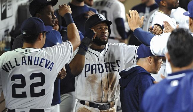 San Diego Padres&#x27; Manuel Margot is congratulated in the dugout after scoring on a RBI single by Carlos Asuaje during the sixth inning of a baseball against the Arizona Diamondbacks game Tuesday, Sept. 19, 2017, in San Diego. (AP Photo/Orlando Ramirez)