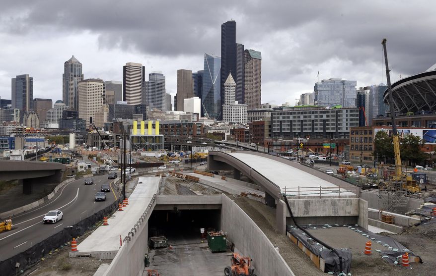 In this file photo taken Tuesday, Sept. 19, 2017, a portion of a new offramp, center right, for Highway 99, stands completed and adjacent to the entrance for northbound traffic into the Highway 99 tunnel still being constructed in Seattle. The offramp has a new type of column that flexes when the ground shakes in an earthquake, then snaps back to its original position so that the structure not only survives a quake without collapsing but also sustains so little damage that it can be used immediately. (AP Photo/Elaine Thompson) ** FILE **