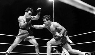 This June 16, 1949, file photo, shows Jake LaMotta, right, fighting Marcel Cerdan in Briggs Stadium in Detroit, Mich. LaMotta knocked out Cerdan in the 10th round to become the new world middleweight champion. LaMotta, whose life was depicted in the film “Raging Bull,” died Tuesday, Sept. 19, 2017, at a Miami-area hospital from complications of pneumonia. He was 95. (AP Photo/File)