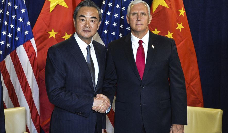 In this photo released by China&#39;s Xinhua News Agency, Chinese Foreign Minister Wang Yi, left, shakes hands as he poses for a photo with Vice President Mike Pence during a meeting at the United Nations headquarters in New York, Wednesday, Sept. 20, 2017. (Li Rui/Xinhua via AP)