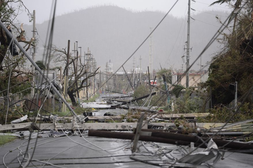Electricity poles and lines lay toppled on the road after Hurricane Maria hit the eastern region of the island, in Humacao, Puerto Rico, Wednesday, Sept. 20, 2017. The strongest hurricane to hit Puerto Rico in more than 80 years destroyed hundreds of homes, knocked out power across the entire island and turned some streets into raging rivers in an onslaught that could plunge the U.S. territory deeper into financial crisis. (AP Photo/Carlos Giusti)