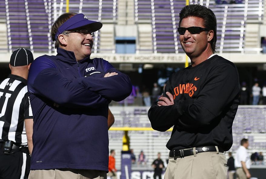 FILE- In this Nov. 19, 2016, file photo, TCU head coach Gary Patterson, left, and Oklahoma State head coach Mike Gundy talk before an NCAA college football game in Fort Worth, Texas. The two teams meet on Saturday. (AP Photo/Jim Cowsert, File)