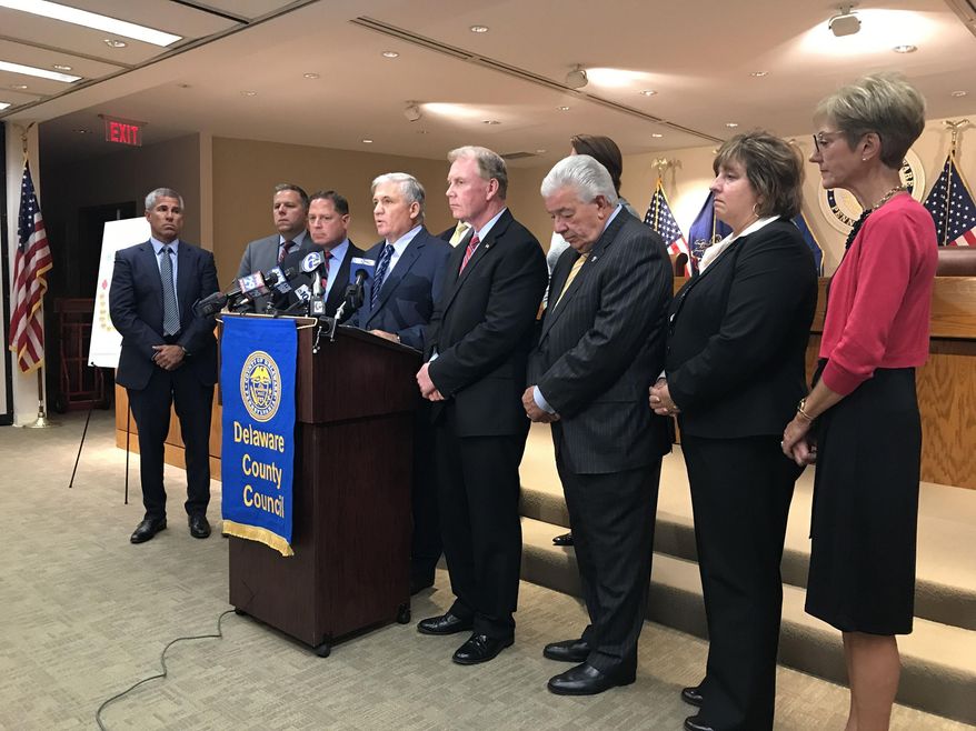 Delaware County, Pa. officials announce the filing of a lawsuit Thursday, Sept. 21, 2017, against 11 makers of opiod painkillers, hoping to stem the tide of drug deaths and overdoses, in Media, Pa. Delaware County sued 11 pharmaceutical companies Thursday for marketing tactics they said misrepresented the dangers of long-term opioid usage amid a national overdose crisis that continues to kill tens of thousands of people annually. (Erin McCarthy/The Philadelphia Inquirer via AP)