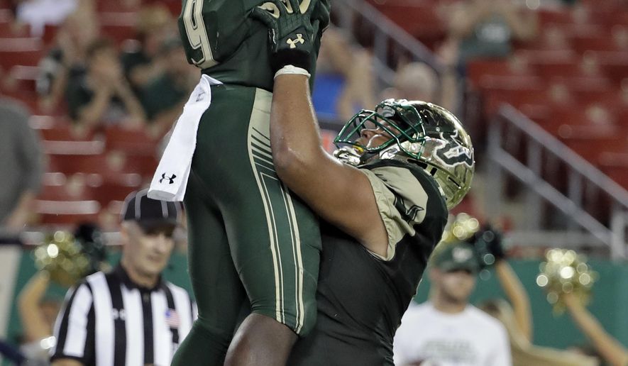 South Florida quarterback Quinton Flowers (9) gets a lift from offensive lineman Cameron Ruff after Flowers scored on a 1-yard touchdown run during the second half of an NCAA college football game against Temple Thursday, Sept. 21, 2017, in Tampa, Fla. (AP Photo/Chris O&#39;Meara)