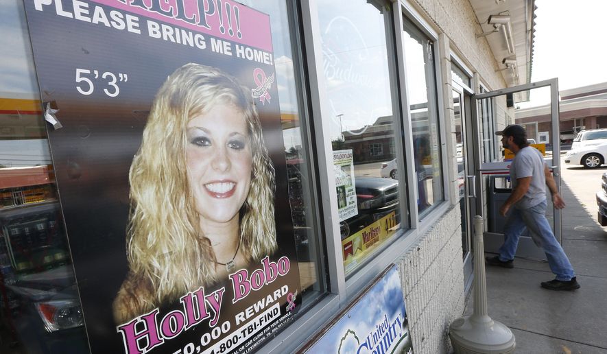 FILE - In this Sept. 9, 2014 file photo, a poster offering a reward for information in the disappearance of Holly Bobo, is displayed in a store window in Parsons, Tenn. The case against Zachary Adams, a man charged with kidnapping, raping and killing Bobo is “absolutely full of holes” and based on “non-evidence,” a defense attorney said Thursday, Sept. 21, 2017. Jennifer Thompson delivered closing arguments Thursday in the trial of Adams in Savannah. (AP Photo/Mark Humphrey, File)