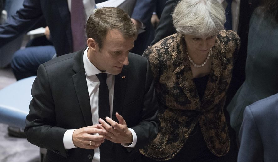 French President Emmanuel Macron speaks to British Prime Minister Theresa May as they leave a high level Security Council meeting on United Nations peacekeeping operations, Wednesday, Sept. 20, 2017 at U.N. headquarters. (AP Photo/Mary Altaffer)