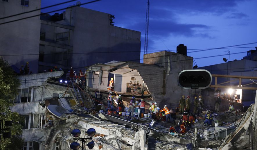 Rescuers race to save people believed to be still alive inside a collapsed office building in the Roma Norte neighborhood of Mexico City, as night falls Friday, Sept. 22, 2017, three days after a 7.1 magnitude earthquake. (AP Photo/Rebecca Blackwell)
