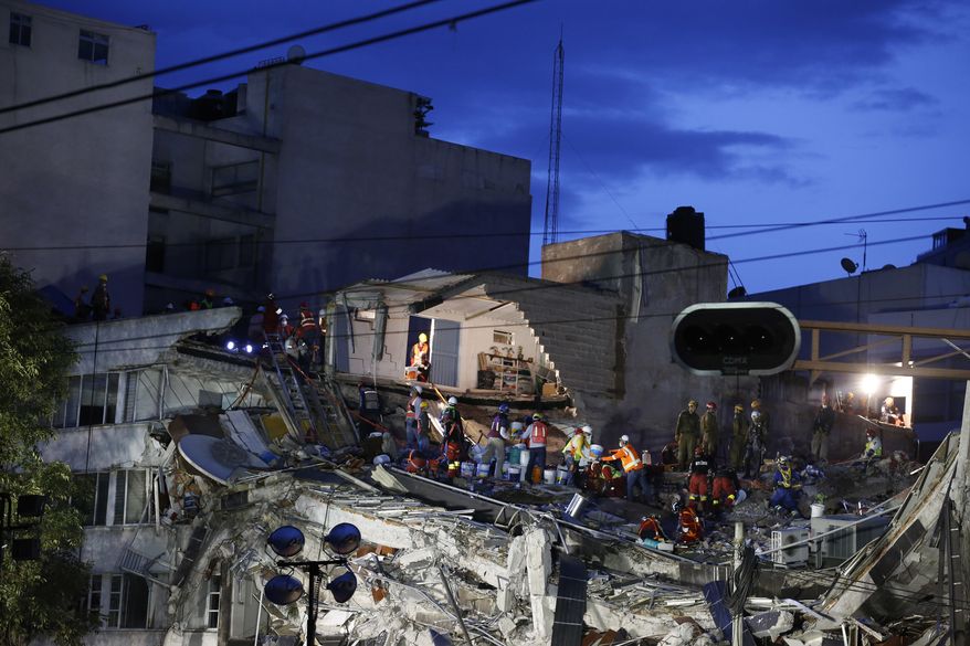Rescuers race to save people believed to be still alive inside a collapsed office building in the Roma Norte neighborhood of Mexico City, as night falls Friday, Sept. 22, 2017, three days after a 7.1 magnitude earthquake. (AP Photo/Rebecca Blackwell)