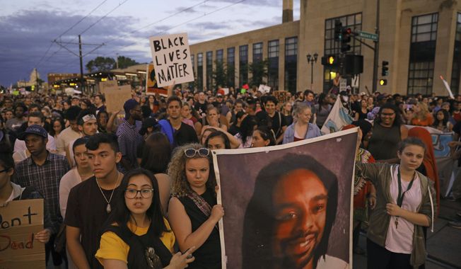 FILE - In this June 16, 2017 file photo, supporters of Philando Castile hold a portrait of  Castile as they march along University Avenue in St. Paul, Minn. The vigil was held after St. Anthony police Officer Jeronimo Yanez was cleared of all charges in the fatal shooting last year of Castile. Changes to a Department of Justice program that had reviewed police departments in hopes of building community trust have dismayed some civil rights advocates and left some cities wondering what to do next. (Anthony Souffle/Star Tribune via AP File)/Star Tribune via AP File)
