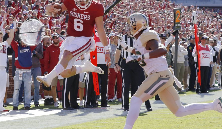 FILE - In this Nov. 12, 2016, file photo, Oklahoma quarterback Baker Mayfield (6) runs in for a touchdown ahead of Baylor safety Davion Hall (2) during the first half of a NCAA college football game in Norman, Okla. Third-ranked Oklahoma is streaking into the Big 12 opener at Baylor on Saturday. The 3-0 Sooners have a nation’s-best 13 straight wins, and a 16-game winning streak in conference play. (AP Photo/Alonzo Adams, File)