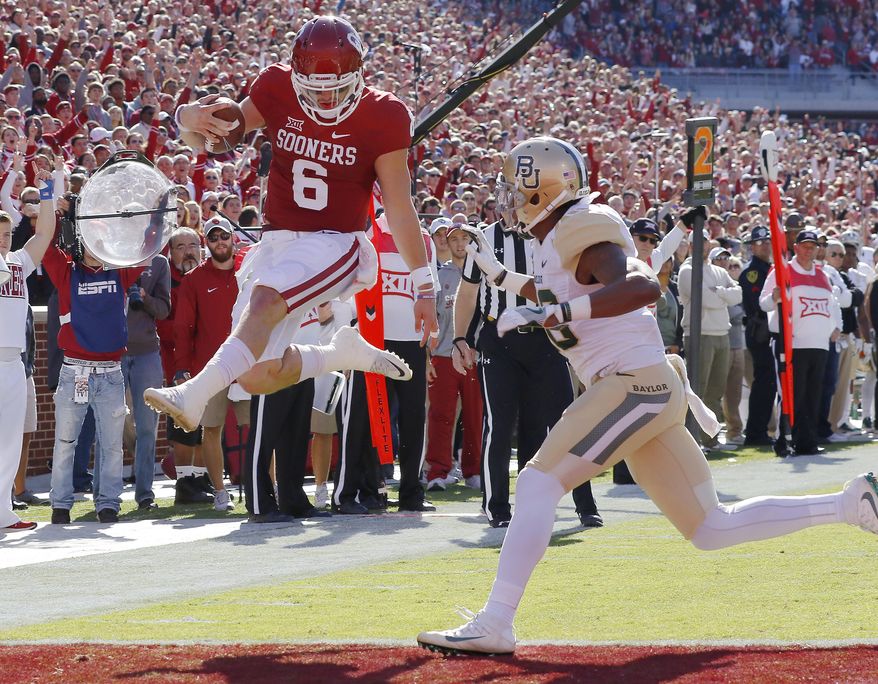 FILE - In this Nov. 12, 2016, file photo, Oklahoma quarterback Baker Mayfield (6) runs in for a touchdown ahead of Baylor safety Davion Hall (2) during the first half of a NCAA college football game in Norman, Okla. Third-ranked Oklahoma is streaking into the Big 12 opener at Baylor on Saturday. The 3-0 Sooners have a nation’s-best 13 straight wins, and a 16-game winning streak in conference play. (AP Photo/Alonzo Adams, File)