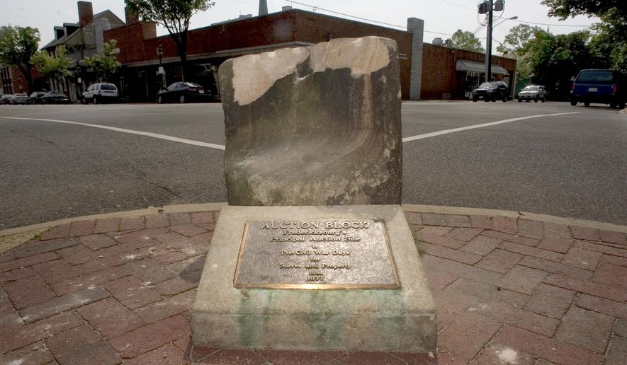 This photo taken May 5, 2005, shows the historic pre-civil war auction block for slaves and property at the corner of Charles and William Streets in downtown Fredericksburg, Va. The NAACP&#39;s Fredericksburg branch is calling for the block to be replaced by a historical panel. Discussions about moving the block began after last month&#39;s deadly violence in Charlottesville, Va.  (Reza A Marvashti /The Free Lance-Star via AP)