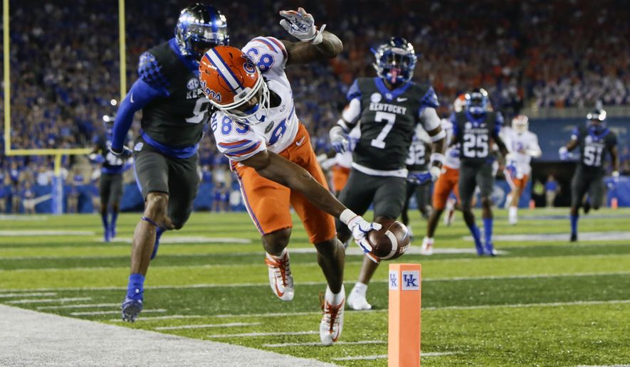 Florida wide receiver Tyrie Cleveland reaches for the goal line in front of Kentucky cornerback Derrick Baity, left, and safety Mike Edwards to score a touchdown during the first half of an NCAA college football game Saturday, Sept. 23, 2017, in Lexington, Ky. (AP Photo/David Stephenson)