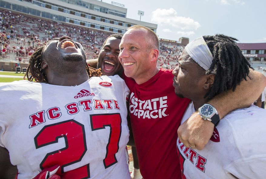 North Carolina State players, from left, Dakwa Nichols (27), defensive tackle B.J. Hill, head coach Dave Doeren and linebacker Jerod Fernandez celebrate defeating Florida State 27-21 in an NCAA college football game in Tallahassee, Fla., Saturday, Sept. 23, 2017. (AP Photo/Mark Wallheiser)