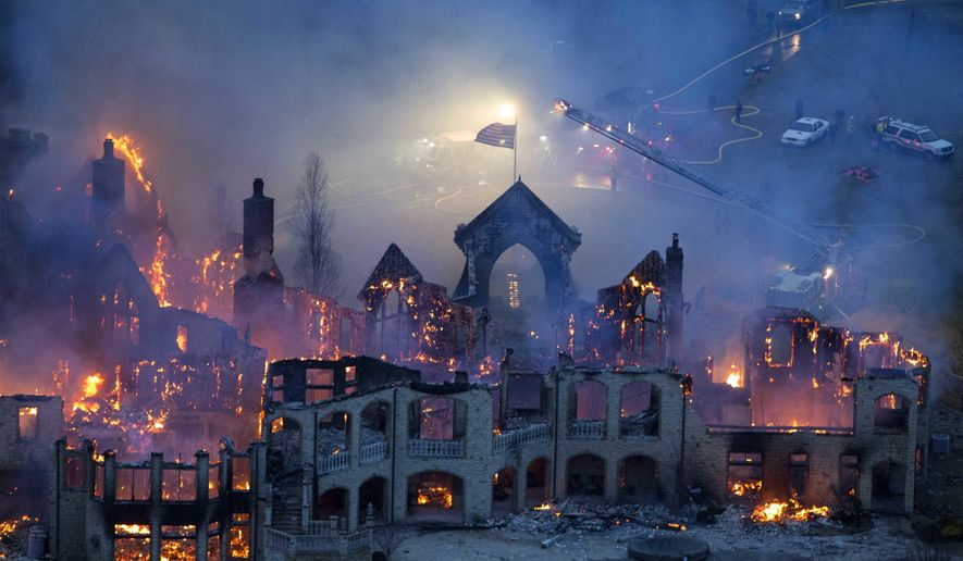 FILE-In this Friday, Jan. 10, 2014 file photo shows firefighters battling a fire at a mansion in Indian Hill, Ohio. A dispute over a multi-million dollar insurance claim for the suburban Cincinnati mansion that burned down in 2014 has been settled weeks before a scheduled trial. (Joseph Fuqua II /The Cincinnati Enquirer via AP)
