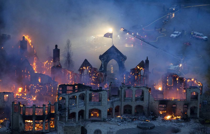 FILE-In this Friday, Jan. 10, 2014 file photo shows firefighters battling a fire at a mansion in Indian Hill, Ohio. A dispute over a multi-million dollar insurance claim for the suburban Cincinnati mansion that burned down in 2014 has been settled weeks before a scheduled trial. (Joseph Fuqua II /The Cincinnati Enquirer via AP)