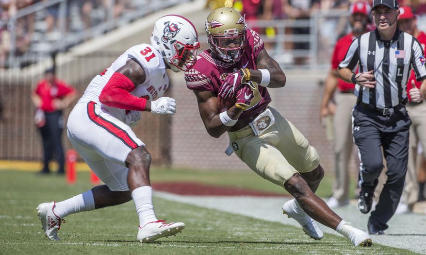 Florida State wide receiver Auden Tate closes his eyes before being hit by North Carolina State defender Jarius Morehead in the first half of an NCAA college football game in Tallahassee, Fla., Saturday, Sept. 23, 2017. (AP Photo/Mark Wallheiser)