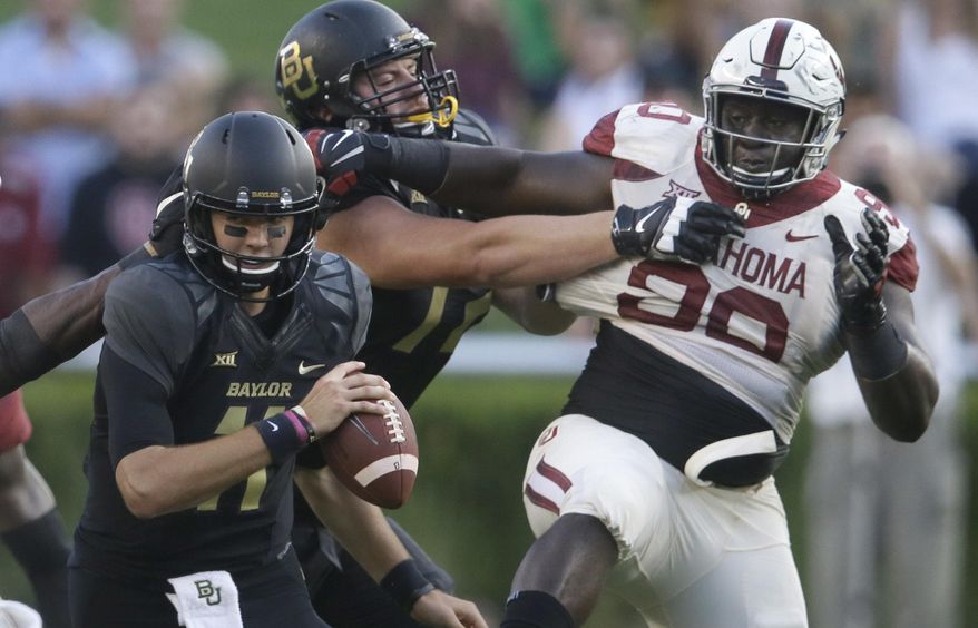 Baylor quarterback Zach Smith (11) turns as teammate offensive lineman Blake Blackmar (72) blocks Oklahoma defensive tackle Neville Gallimore (90) during the first half of an NCAA college football game in Waco, Texas, Saturday, Sept. 23, 2017. (AP Photo/LM Otero)