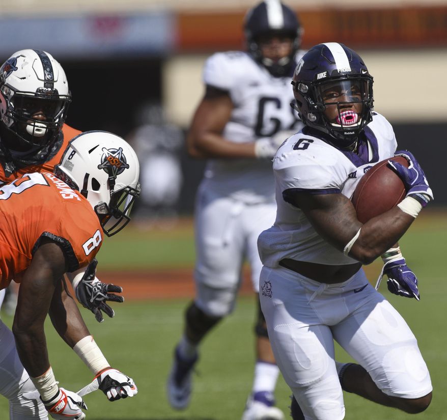 TCU running back Darius Anderson, right, break away from Oklahoma State defensive end Tralund Webber, left, and safety Za'Carrius Green to score a touchdown during the first half of an NCAA college football game in Stillwater, Okla., Saturday, Sept. 23, 2017.(AP Photo/Brody Schmidt)