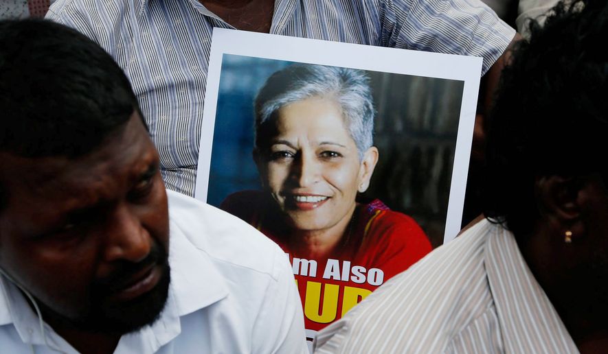 A poster of slain Indian journalist Gauri Lankesh is shown held by a protester at a recent vigil.    Associated Press photo