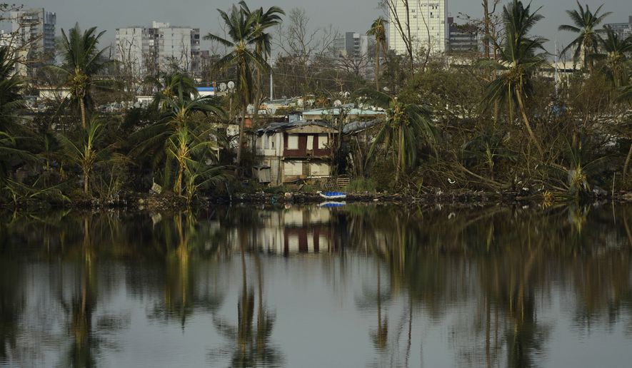 Trees are reflected in the water in the Buena Vista community in the aftermath of Hurricane Maria in San Juan, Puerto Rico, Sunday, Sept. 24, 2017. (AP Photo/Carlos Giusti)