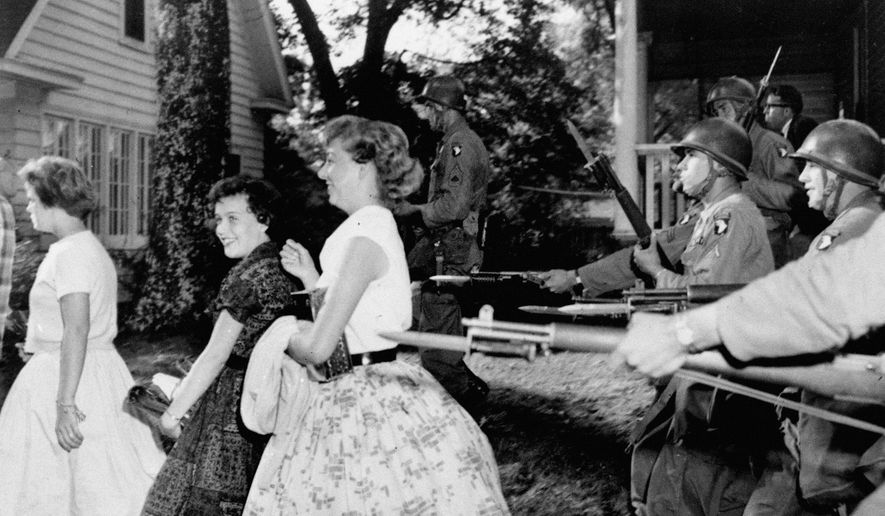 FILE - In this Sept. 25, 1957, file photo, white girls from Central High School laugh as troopers with bayonets force them to move in Little Rock, Ark. Federal forces were used to enforce integration in the face of racial tension in Arkansas. (AP Photo/File)