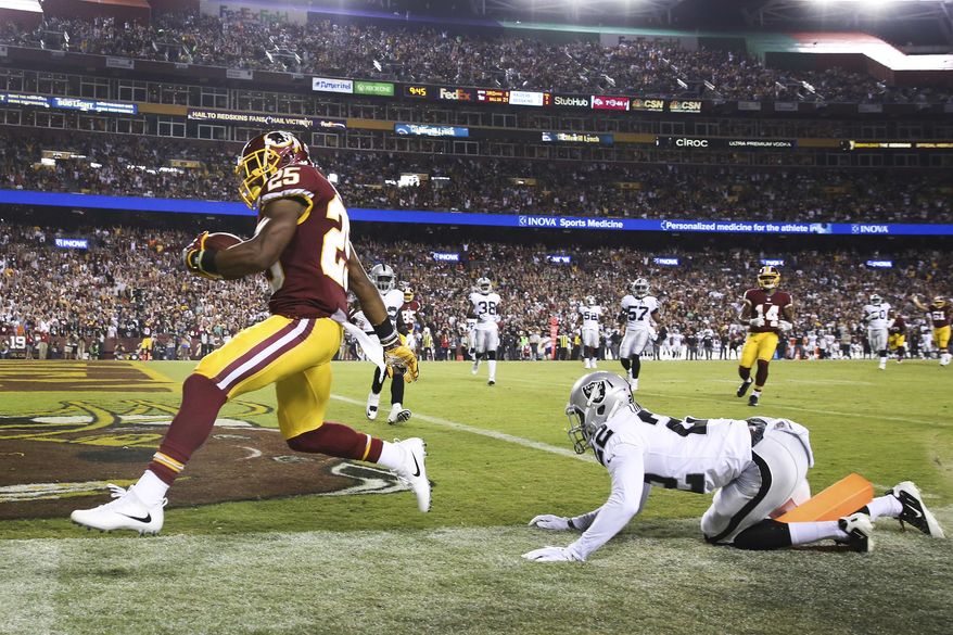 Washington Redskins running back Chris Thompson (25) carries the ball into the end zone for a touchdown as Oakland Raiders cornerback Gareon Conley (22) looks on during the first half of an NFL football game in Landover, Md., Sunday, Sept. 24, 2017. (AP Photo/Pablo Martinez Monsivais)