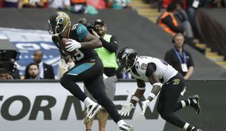 Jacksonville Jaguars tight end Marcedes Lewis, left, scores a touchdown past Baltimore Ravens strong safety Tony Jefferson during the second half of an NFL football game at Wembley Stadium in London, Sunday Sept. 24, 2017. (AP Photo/Matt Dunham)