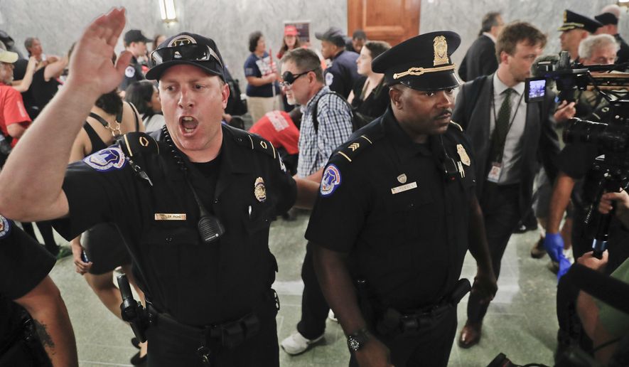 U.S. Capitol Police begin to clear the hallways in an effort to maintain order outside the Senate Finance Committee hearing on the last-ditch GOP push to overhaul the nation&#x27;s health care system, on Capitol Hill in Washington, Monday, Sept. 25, 2017. (AP Photo/Pablo Martinez Monsivais)