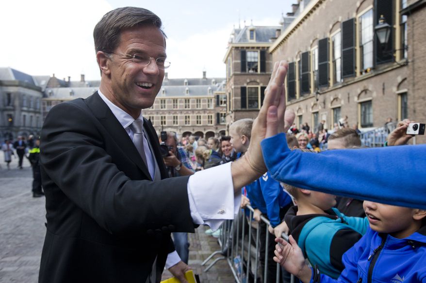 In this Sept. 19, 2017, file photo Dutch Prime Minister Mark Rutte high-fives with children as arrives in The Hague, Netherlands, for a ceremony marking the opening of the parliamentary year. If Angela Merkel wants to know how tough it could be to form a new government, the German Chancellor need only take a look across the border to the Netherlands, where coalition talks are still grinding on more than 6 months after elections. (AP Photo/Peter Dejong, File)